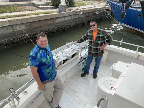 Two anglers on the back deck at the dock