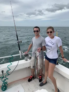 Two anglers offshore with a fish between them
