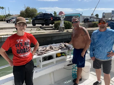 Three anglers at the dock with the day’s catch on the table