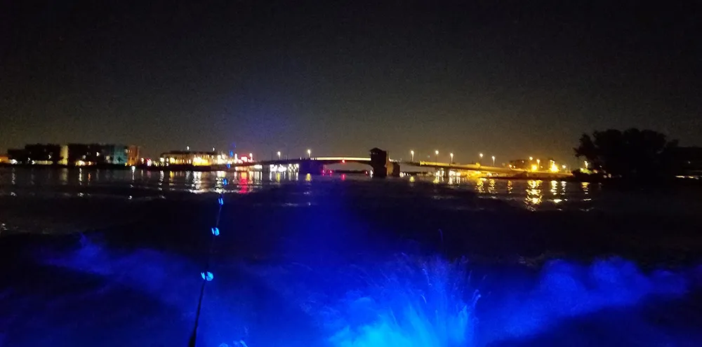 Running out through Johns Pass at night, the bridge lit up behind the boat’s wake